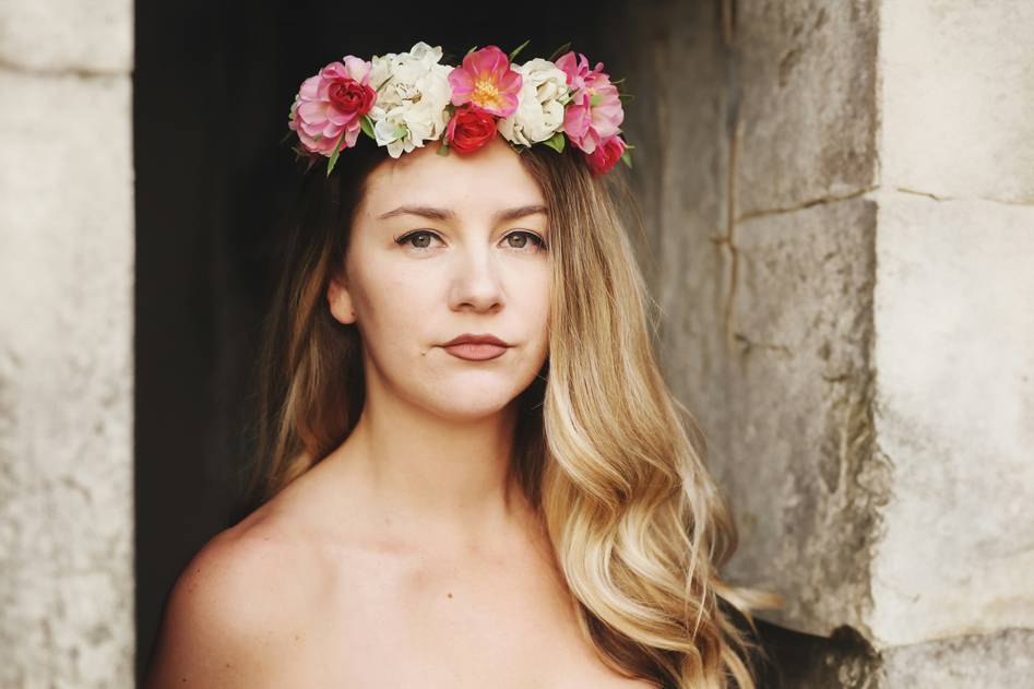 Stylist arranging fresh flowers into an elegant hair crown